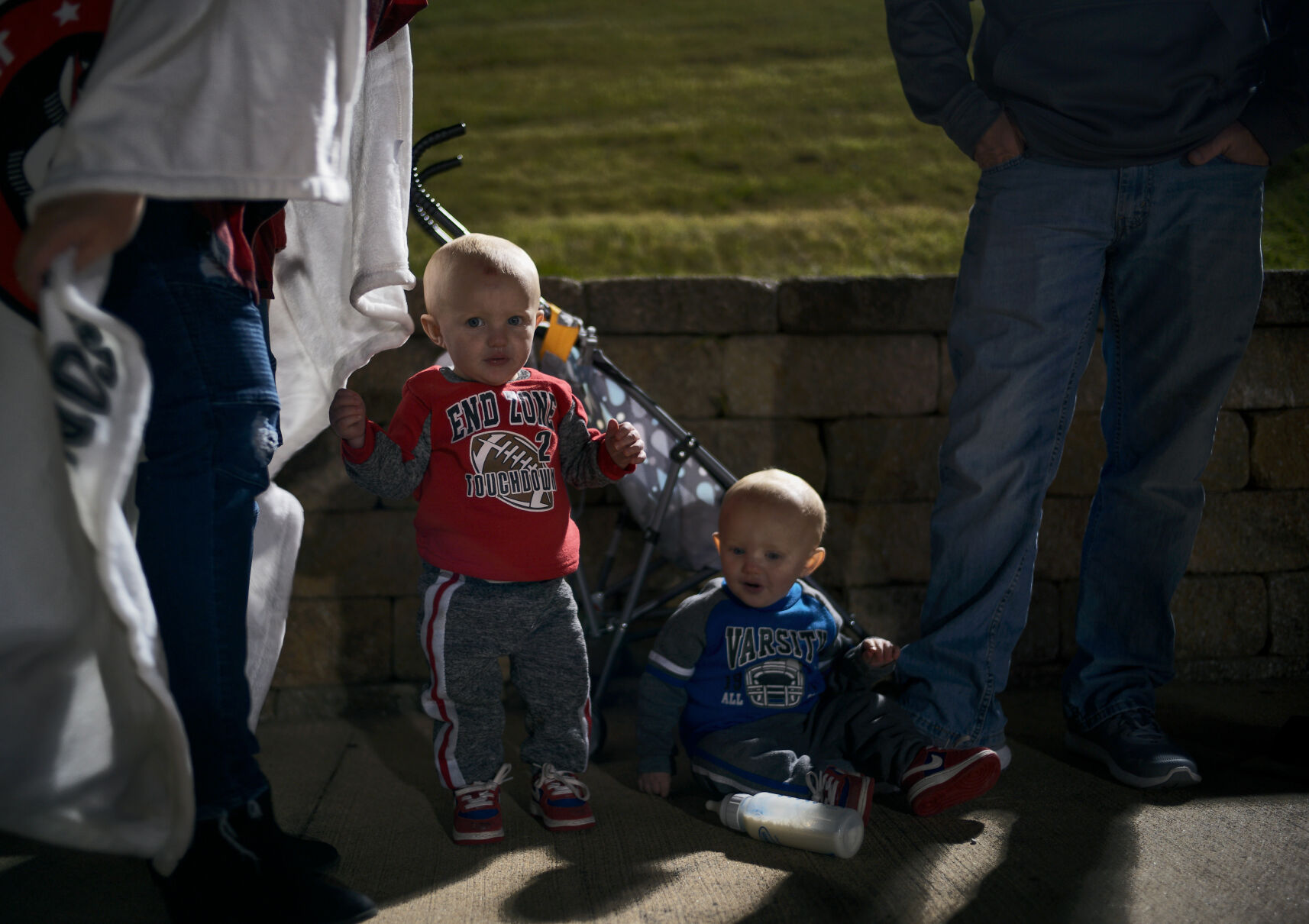 Kolton Drone, 1, and his twin Klayton Drone watch their big sister cheer